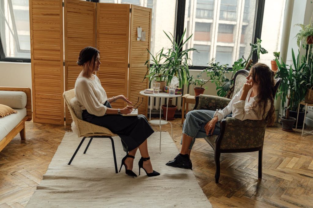 pexels-photo-5217851 Woman in White Shirt Sitting on Chair